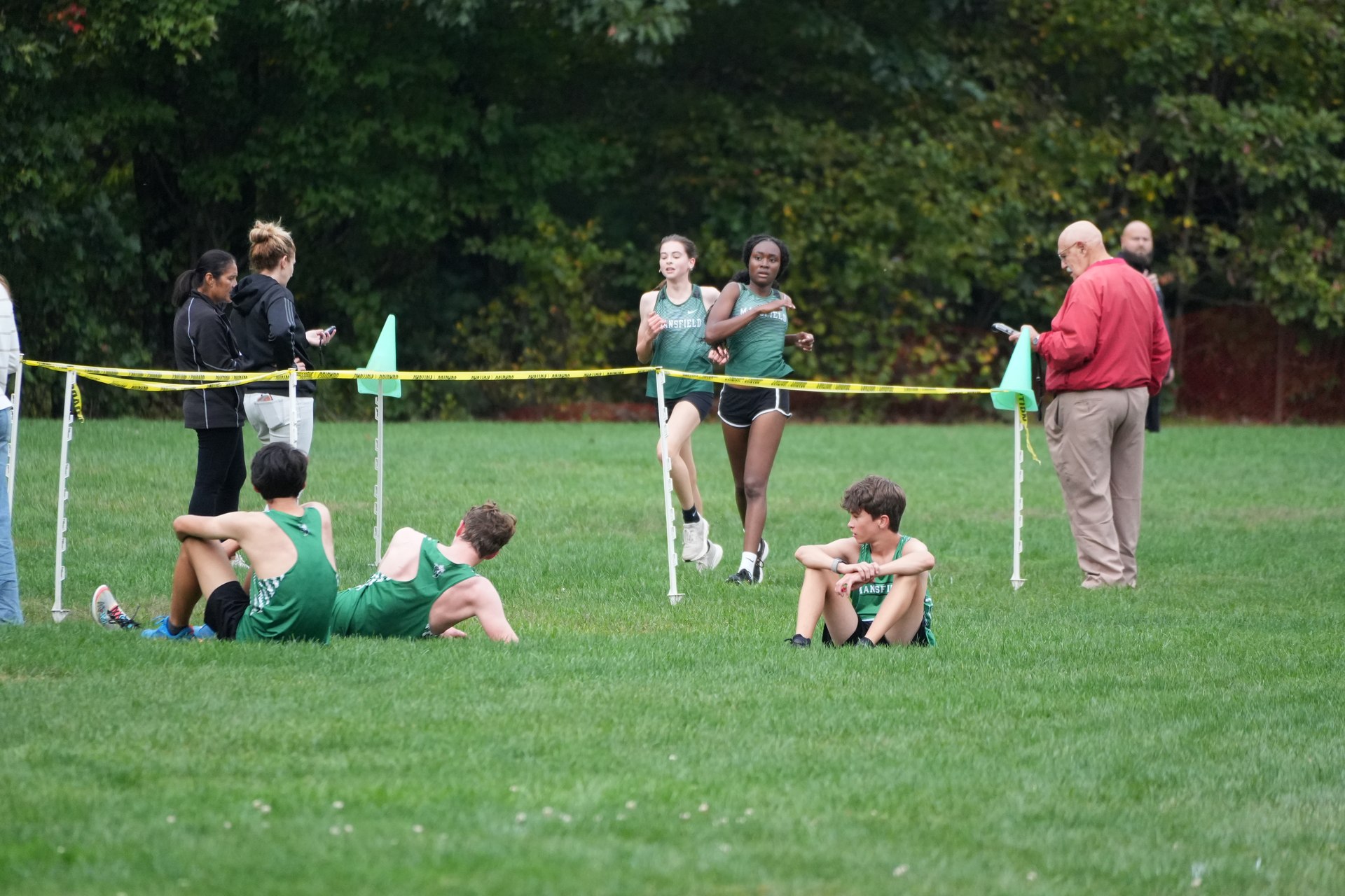 Mansfield runners coming through, with teammates resting beside the lane.
