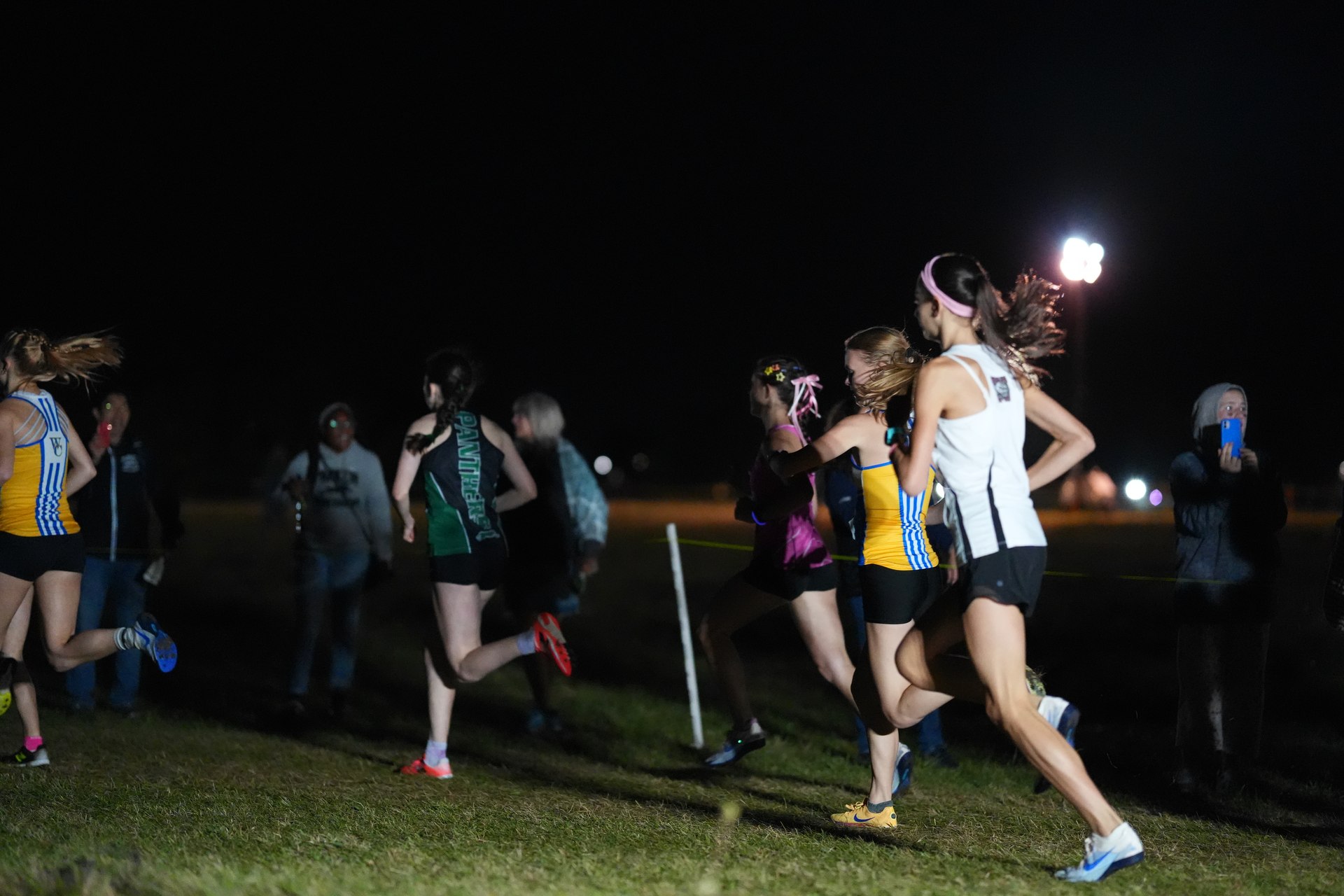 The girls varsity field passes the spectators at Wrentham.
