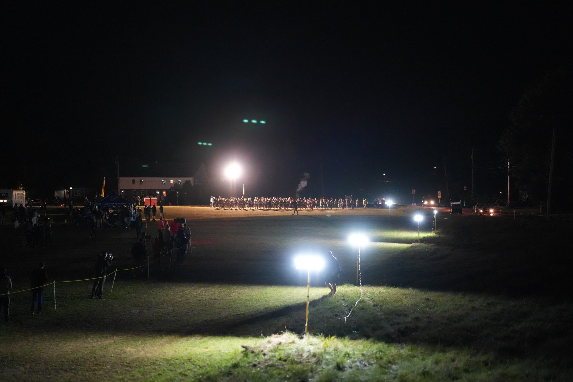 Floodlights and a line of spectators frame the course.