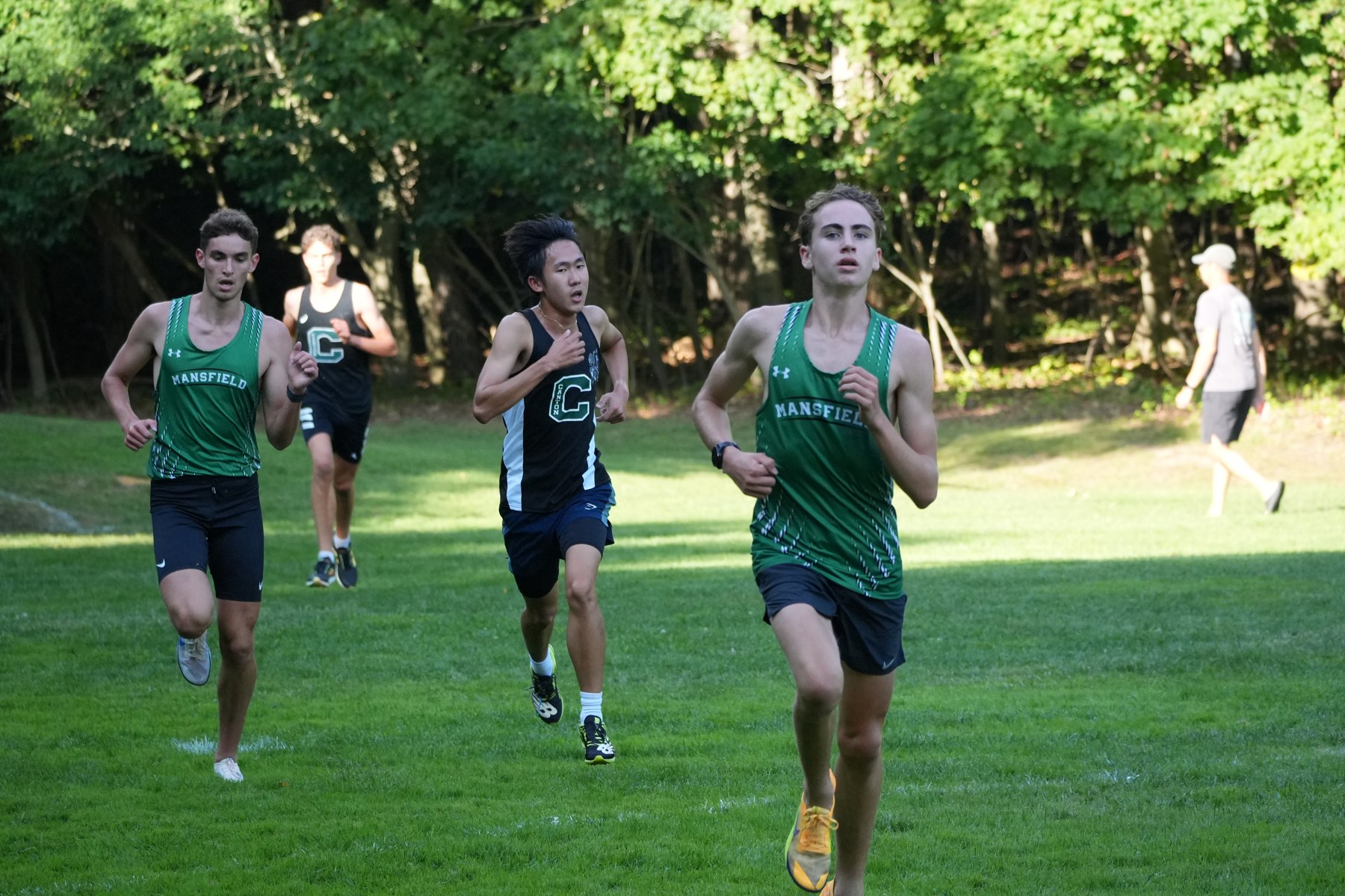 Mansfield and Canton runners crossing the grass.