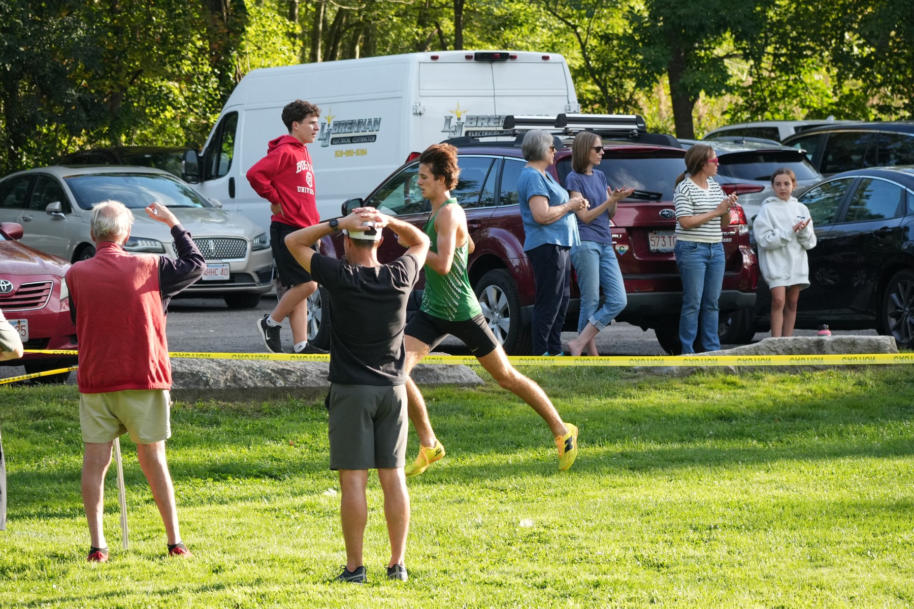 A Mansfield runner passing spectators beside yellow tape.