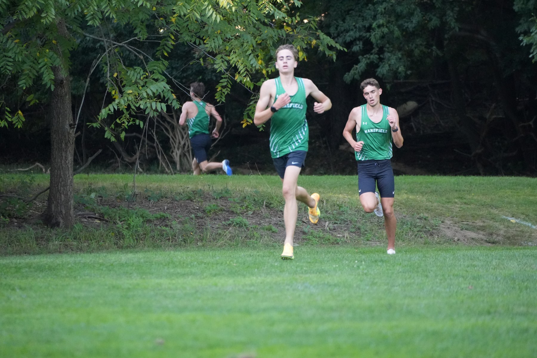 Mansfield runners descending a small grassy hill.