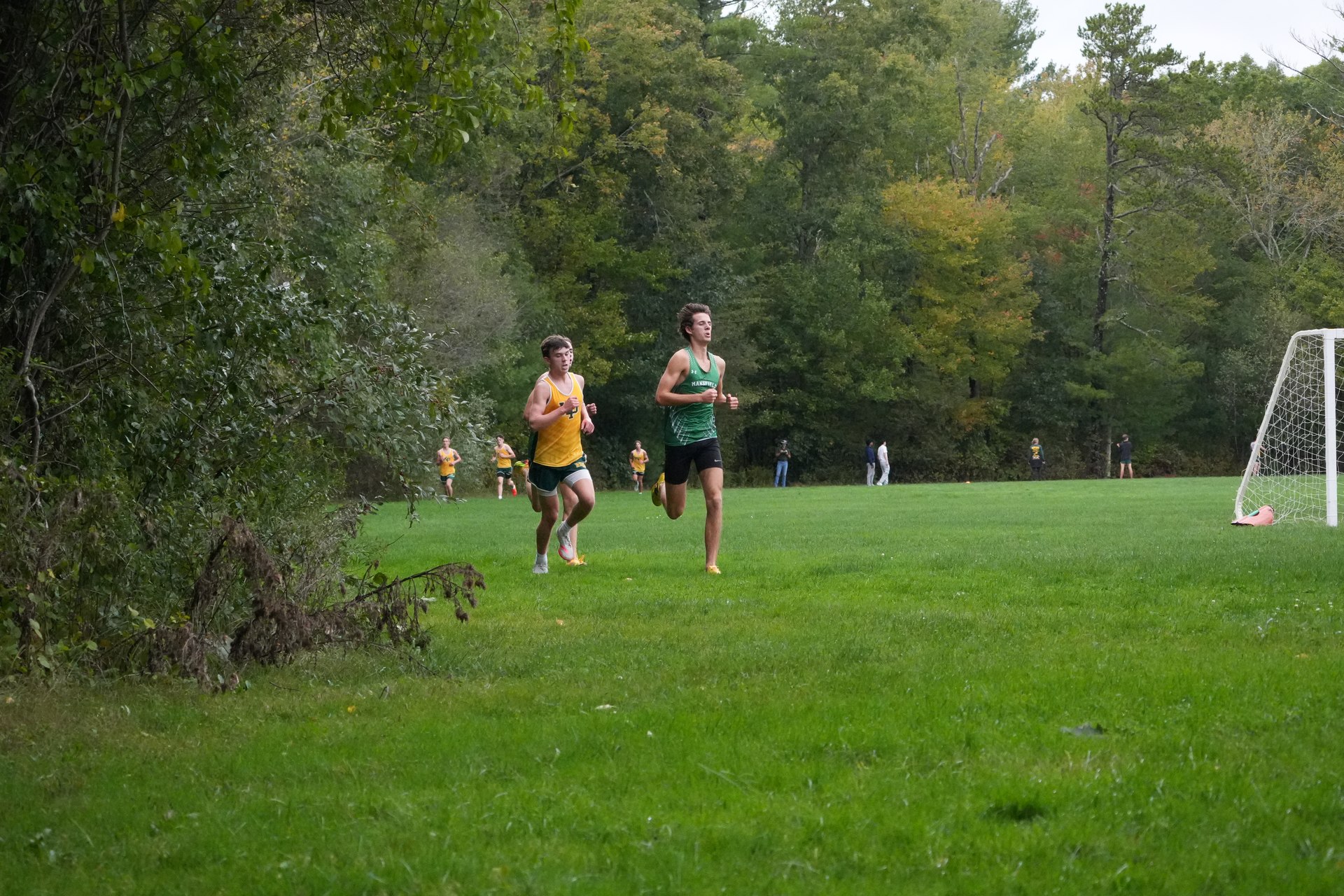 A Mansfield runner and a King Philip runner on the open grass.